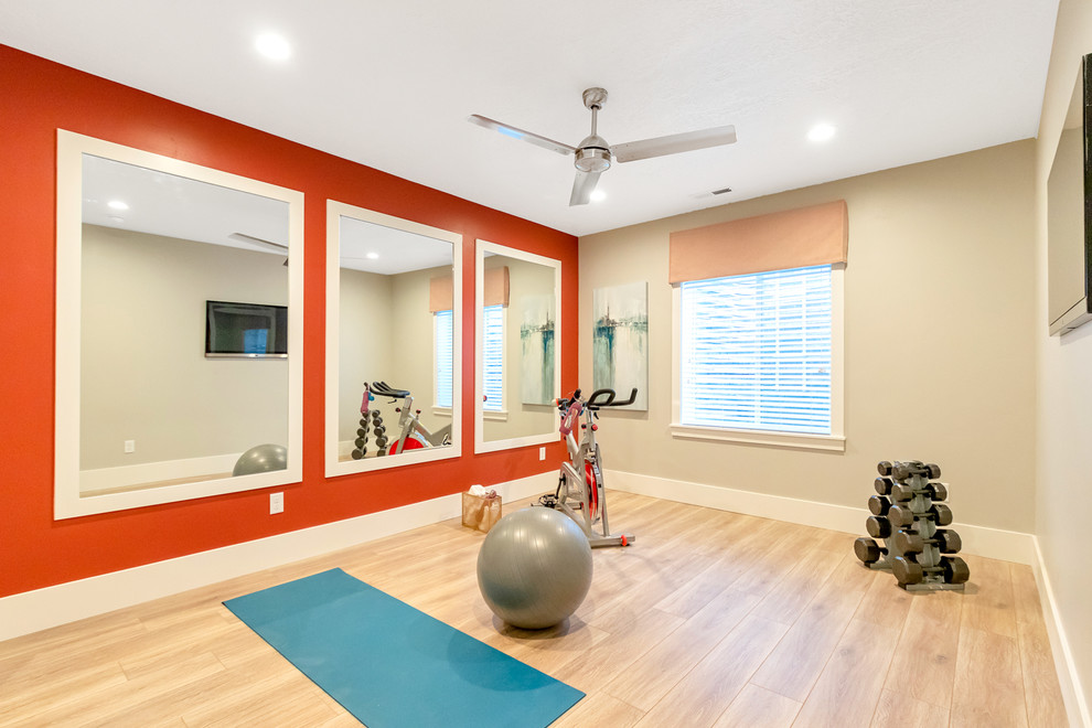 Idee per una sala pesi con pareti arancioni, pavimento in laminato e pavimento beige