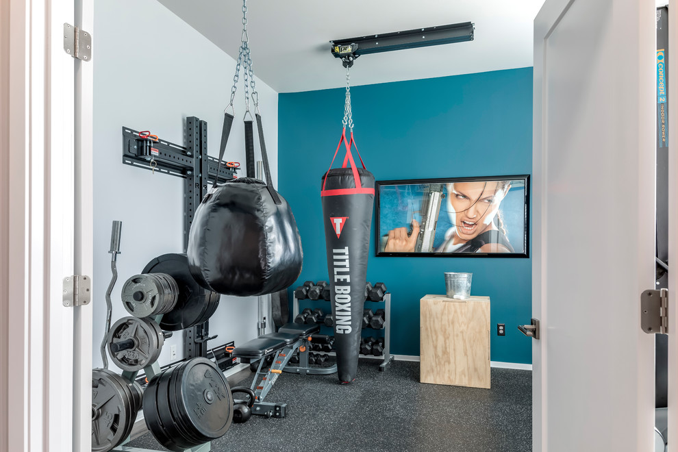This is an example of a medium sized modern home weight room in Seattle with blue walls, cork flooring and black floors.