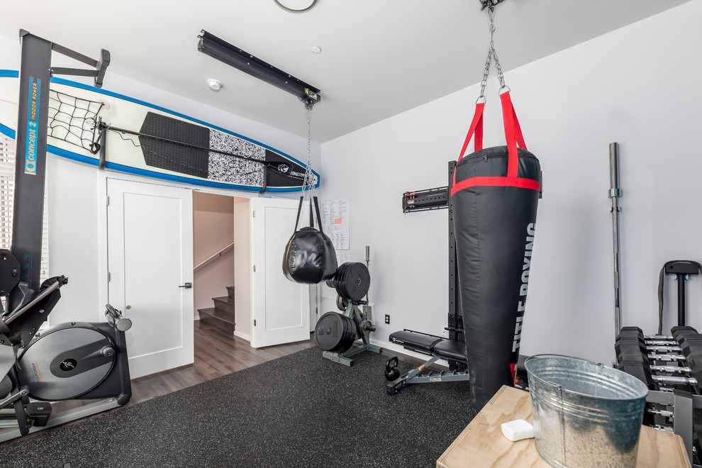 Cette image montre une salle de musculation minimaliste de taille moyenne avec un mur bleu, un sol en liège et un sol noir.