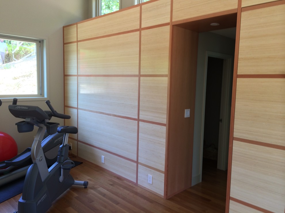 This is an example of a medium sized contemporary multi-use home gym in San Francisco with white walls and light hardwood flooring.