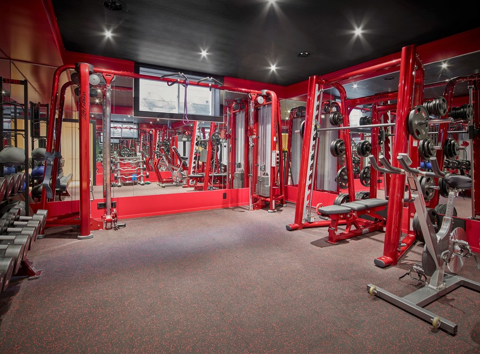 Exemple d'une grande salle de musculation moderne avec un mur rouge et un sol gris.