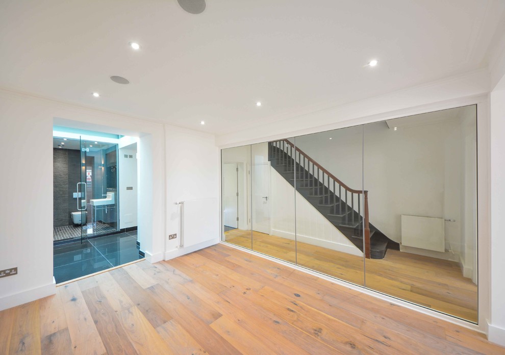 Multifunktionaler, Geräumiger Moderner Fitnessraum mit weißer Wandfarbe und hellem Holzboden in Kent