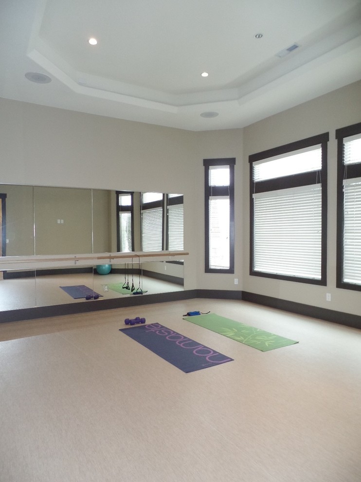 Immagine di uno studio yoga chic di medie dimensioni con pareti beige, pavimento in vinile e pavimento beige