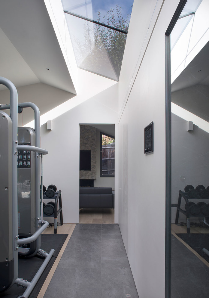 На фото: универсальный домашний тренажерный зал среднего размера в современном стиле с белыми стенами, светлым паркетным полом и бежевым полом