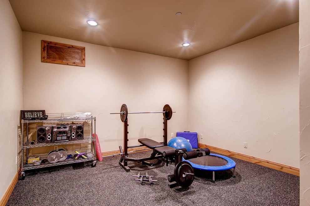 Imagen de sala de pesas clásica pequeña con paredes blancas y moqueta