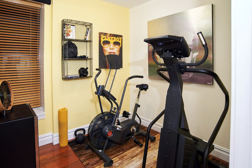 Multifunktionaler, Kleiner Eklektischer Fitnessraum mit gelber Wandfarbe und braunem Holzboden in New York