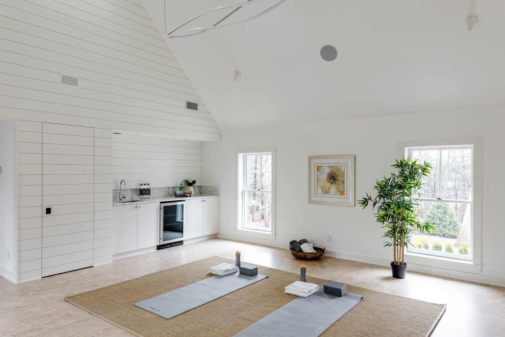 Exemple d'un grand studio de yoga chic avec un mur blanc, un sol en liège et un sol marron.
