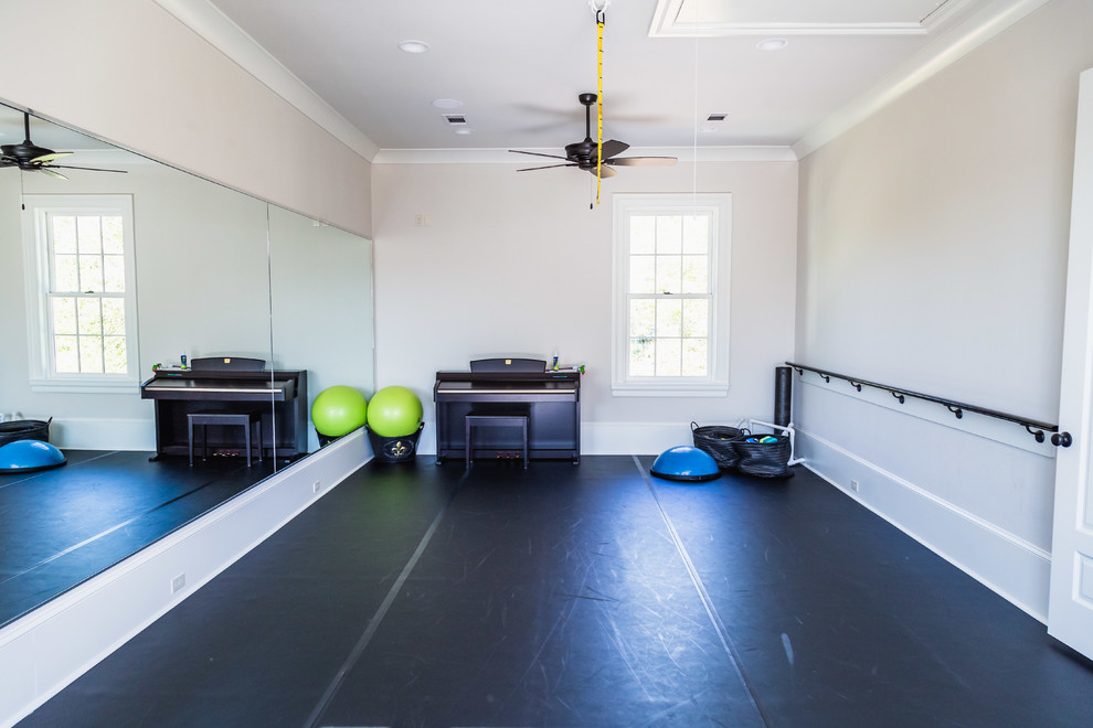 Großer Klassischer Fitnessraum mit beiger Wandfarbe, gebeiztem Holzboden und schwarzem Boden in Sonstige