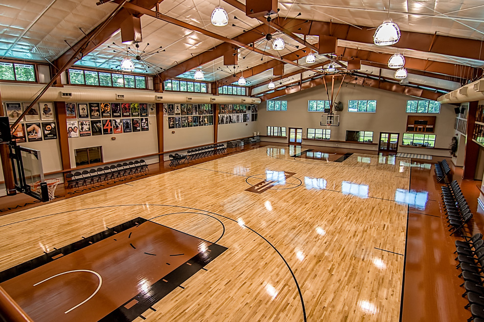 This is an example of a large farmhouse indoor sports court in Atlanta with beige walls, light hardwood flooring and feature lighting.