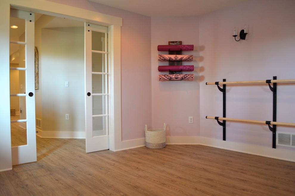 Mittelgroßer Country Yogaraum mit lila Wandfarbe und braunem Holzboden in Detroit
