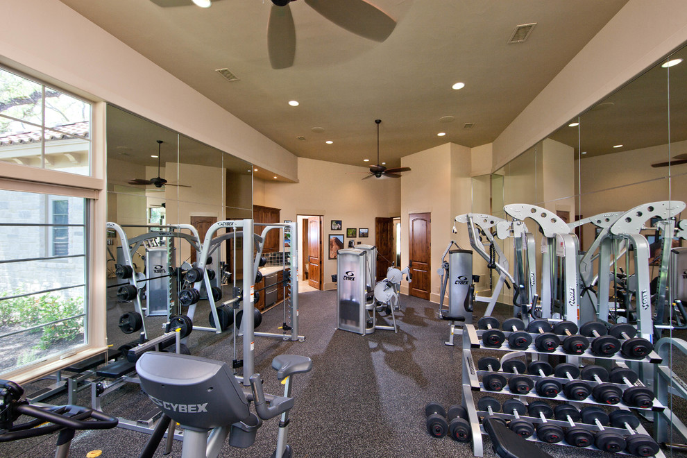 Foto de sala de pesas clásica grande con paredes beige