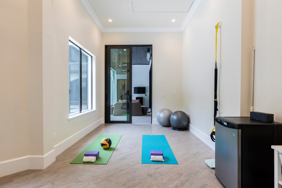 This is an example of a medium sized modern multi-use home gym in Orlando with beige walls, cork flooring and beige floors.