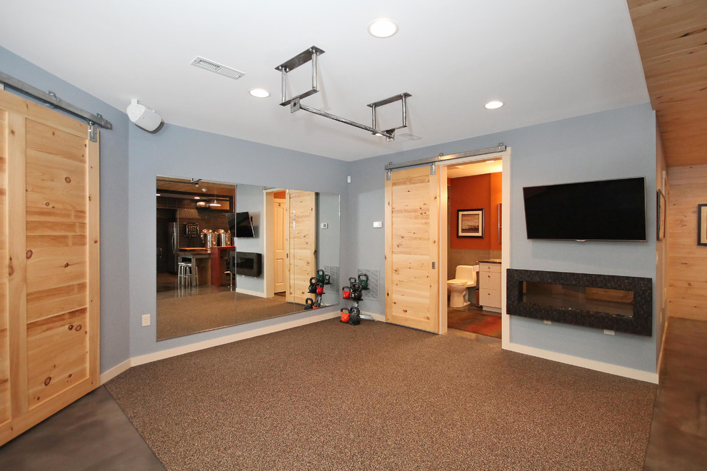 Foto på ett mellanstort funkis hemmagym med fria vikter, med blå väggar, betonggolv och brunt golv