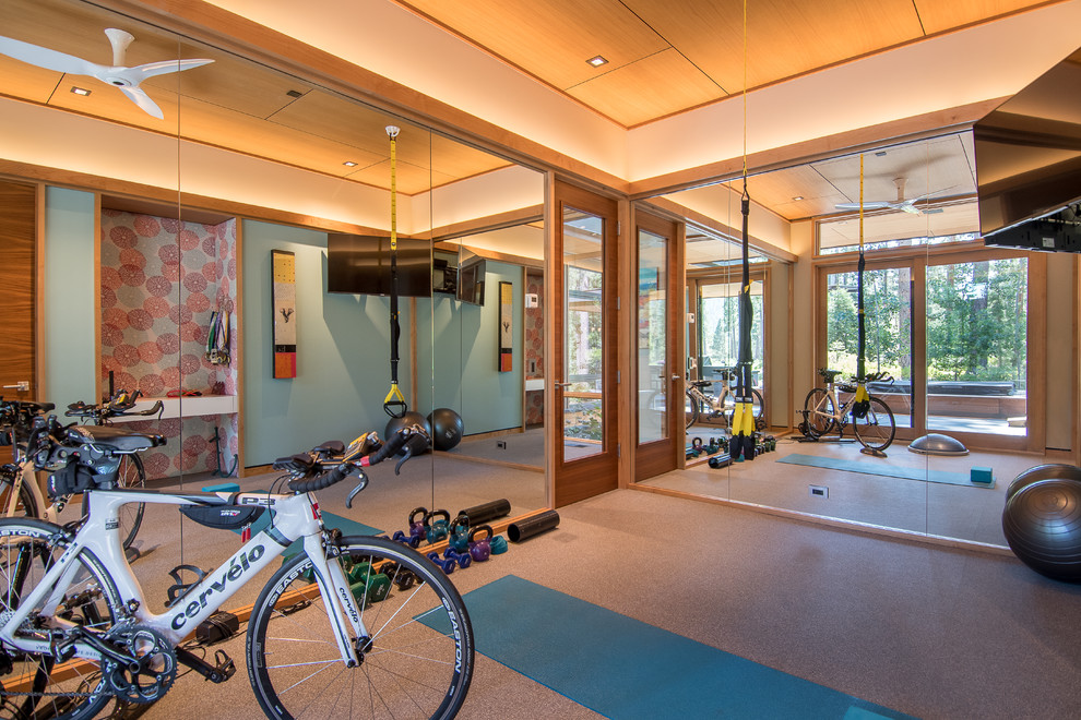 This is an example of a medium sized modern multi-use home gym in Other with white walls and brown floors.