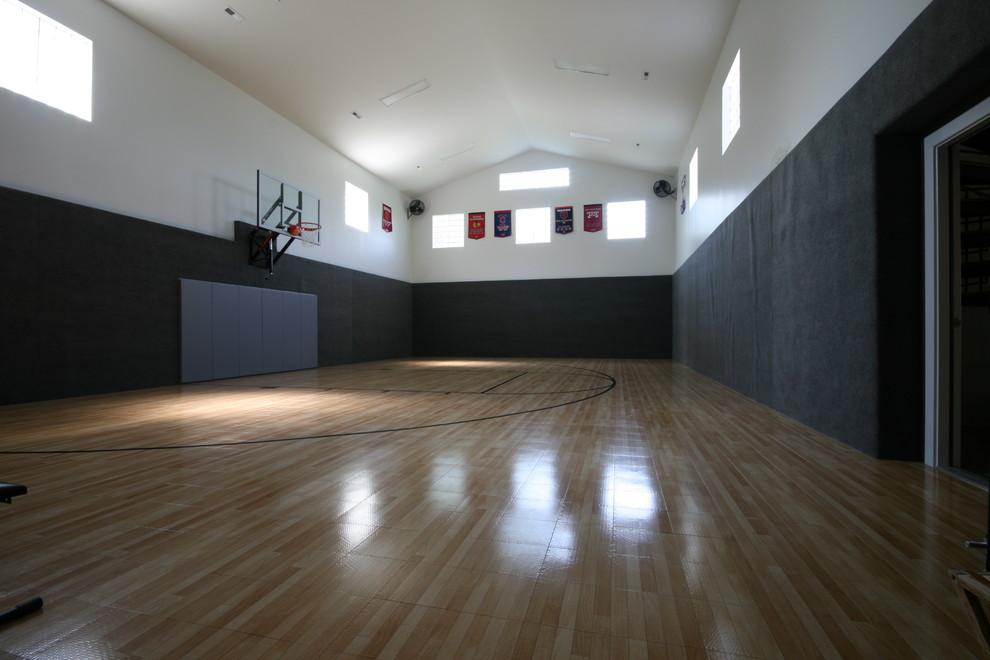 На фото: большой спортзал в классическом стиле с черными стенами и светлым паркетным полом