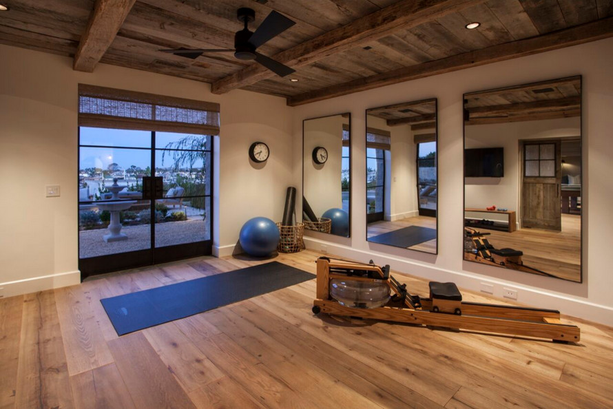Multifunktionaler, Großer Mediterraner Fitnessraum mit beiger Wandfarbe und braunem Holzboden in Orange County