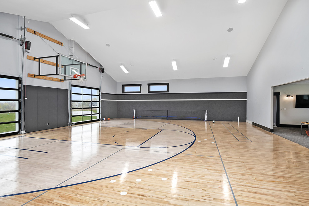 Geräumiger Landhaus Fitnessraum mit Indoor-Sportplatz, grauer Wandfarbe, hellem Holzboden und braunem Boden in Grand Rapids