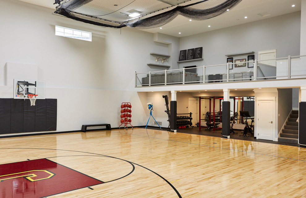 Exemple d'une très grande salle de sport chic multi-usage avec un mur gris, un sol en bois brun et un sol marron.
