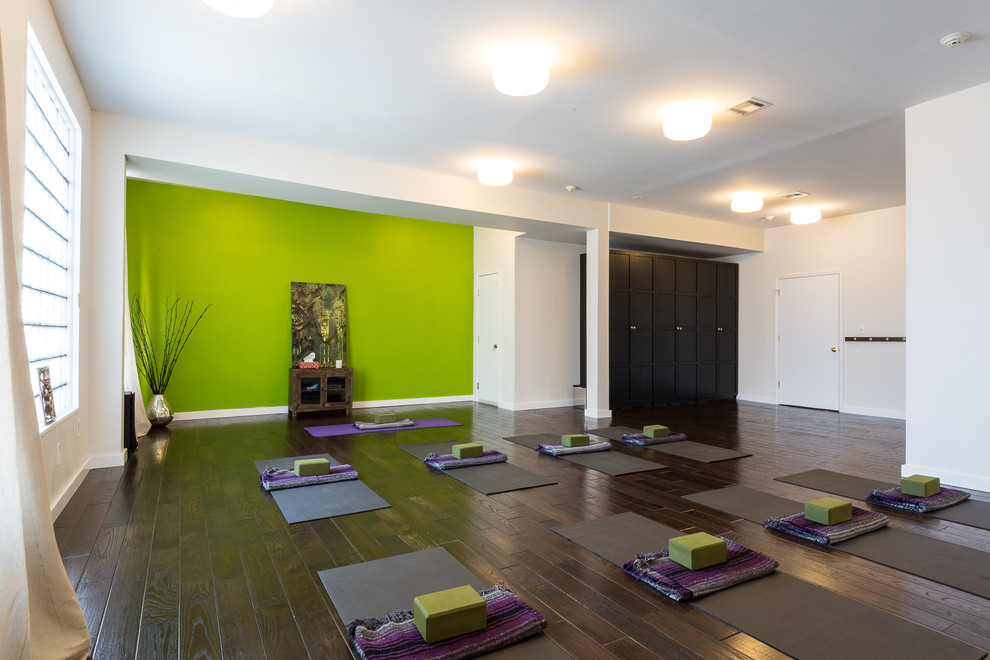 Großer Moderner Yogaraum mit dunklem Holzboden und grüner Wandfarbe in New York