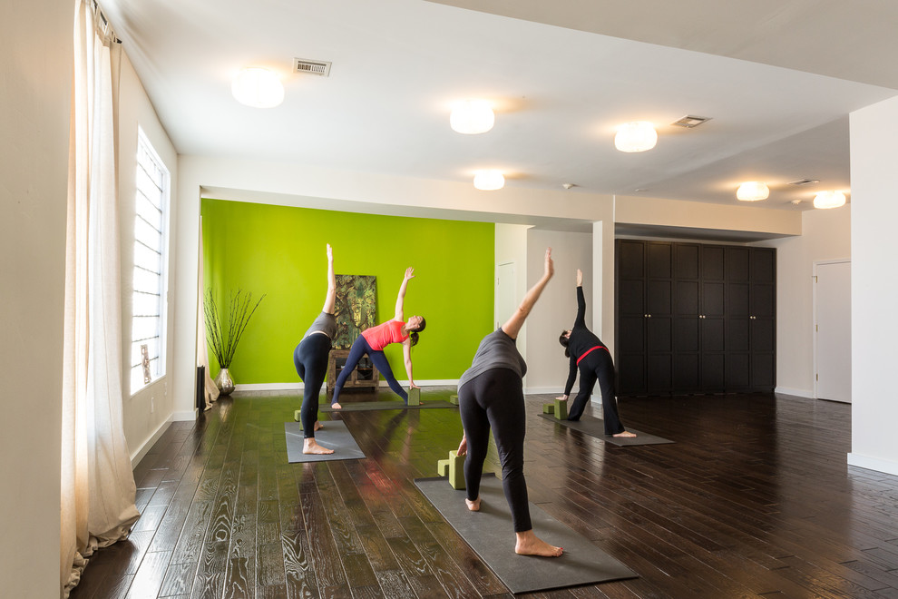 Esempio di un grande studio yoga minimal con pareti verdi e parquet scuro