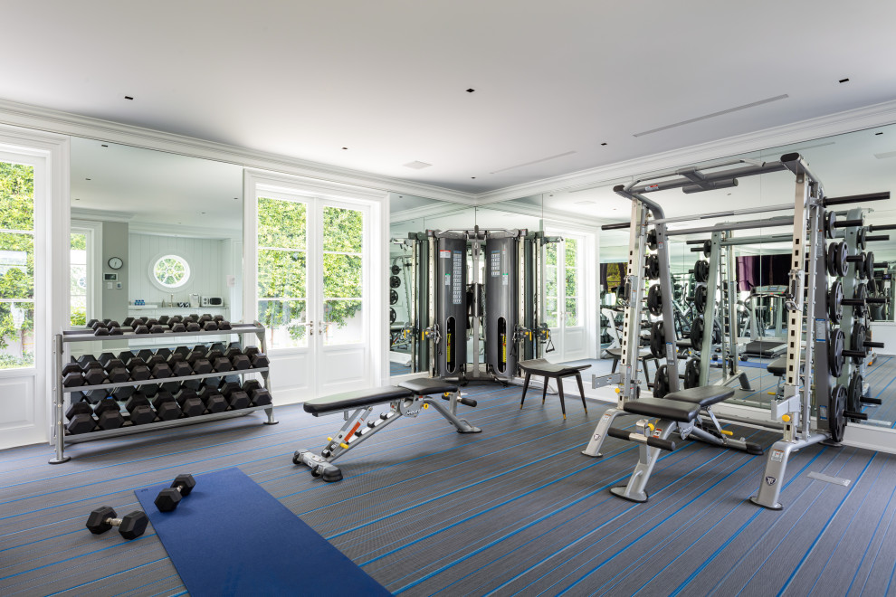Cette image montre une grande salle de musculation design avec un mur blanc, moquette et un sol multicolore.