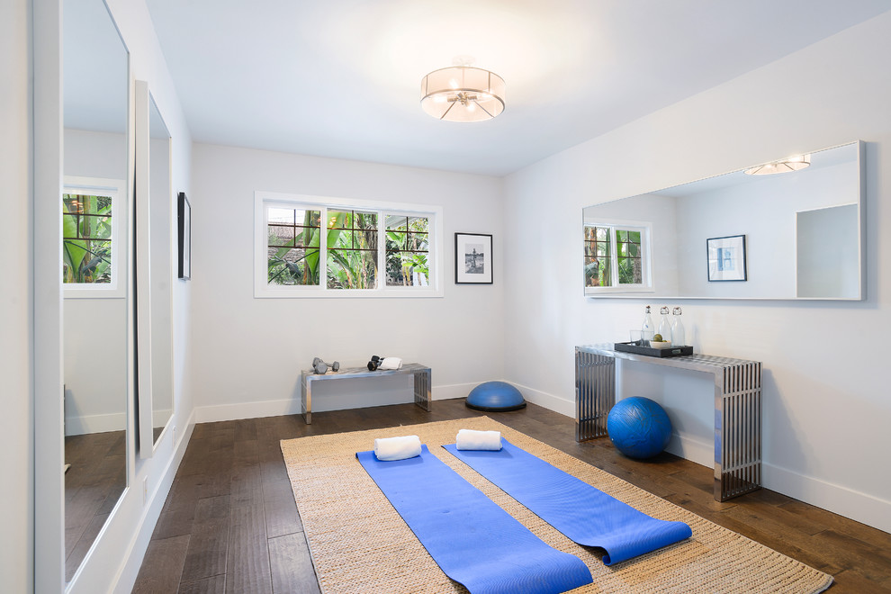 Klassischer Yogaraum mit weißer Wandfarbe, dunklem Holzboden und braunem Boden in Los Angeles