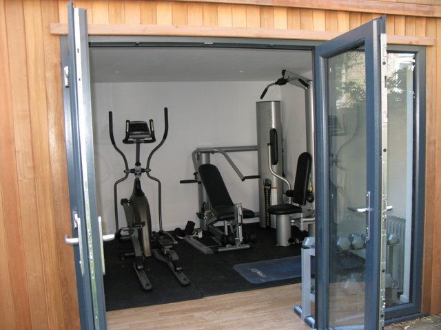 Photo of a medium sized contemporary multi-use home gym in Other with white walls and light hardwood flooring.