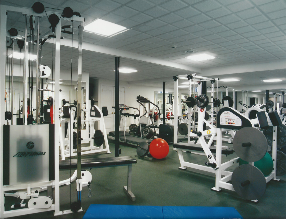 Imagen de sala de pesas actual grande con paredes blancas