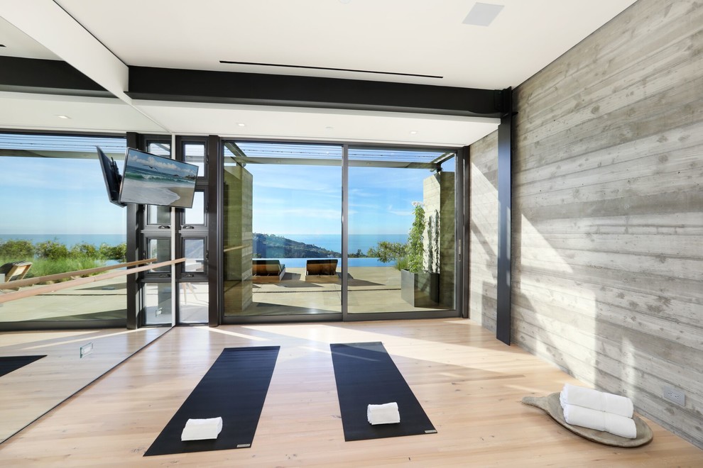 Mittelgroßer Moderner Yogaraum mit grauer Wandfarbe, hellem Holzboden und braunem Boden in Orange County