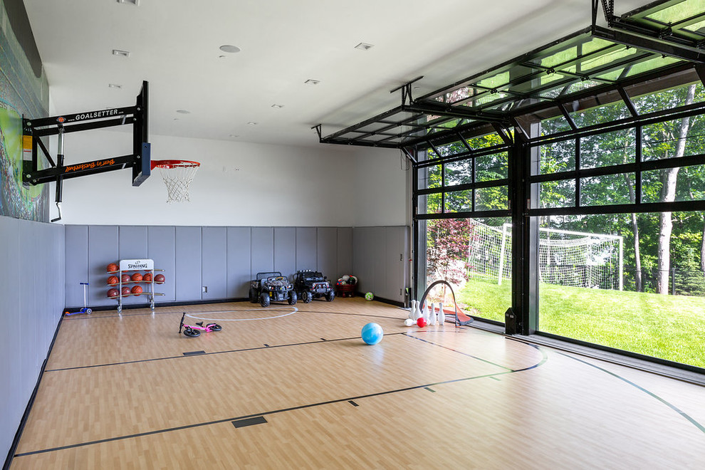 Moderner Fitnessraum mit Indoor-Sportplatz, weißer Wandfarbe, hellem Holzboden und beigem Boden in Chicago