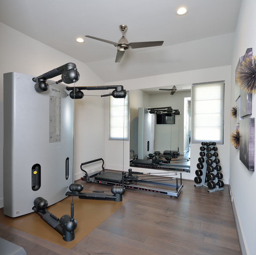 Diseño de sala de pesas contemporánea de tamaño medio con paredes blancas, suelo de madera en tonos medios y suelo marrón