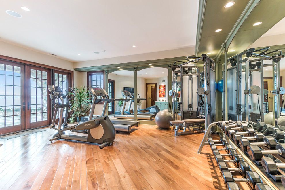 Example of a large trendy medium tone wood floor home weight room design in Milwaukee with beige walls