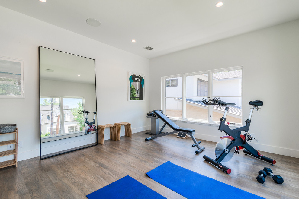 Großer Moderner Yogaraum mit weißer Wandfarbe und hellem Holzboden in Dallas