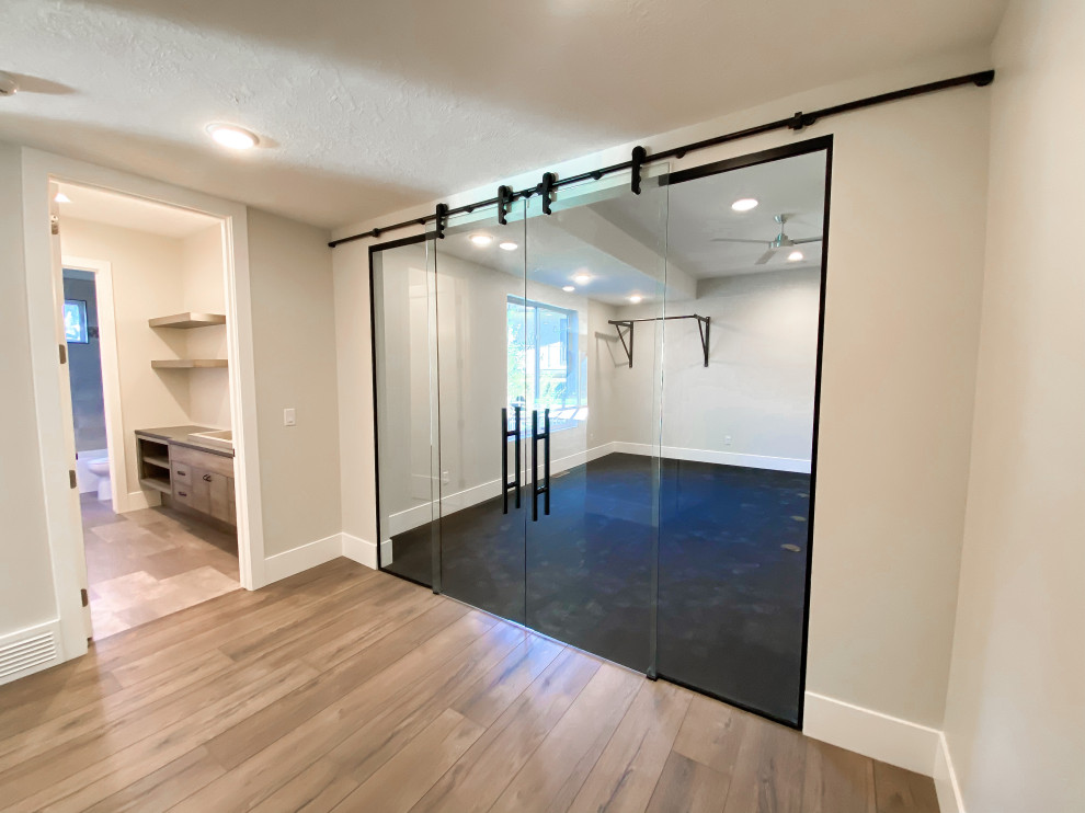 Großer Moderner Yogaraum mit weißer Wandfarbe, Vinylboden und schwarzem Boden in Salt Lake City