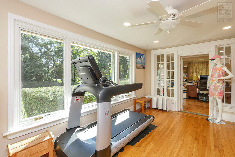 Design ideas for a medium sized multi-use home gym in New York with beige walls and medium hardwood flooring.