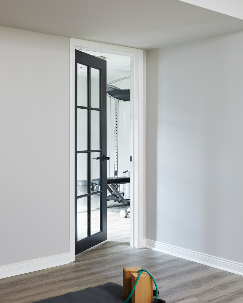 Foto di una piccola sala pesi minimal con pareti beige, pavimento in laminato e pavimento grigio