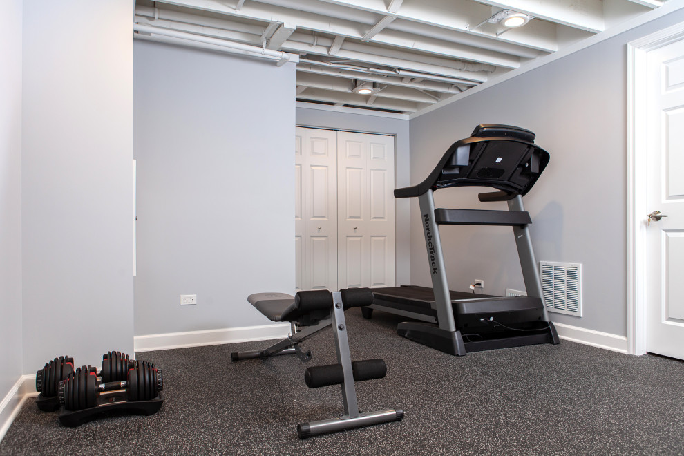 This is an example of a mid-sized transitional multipurpose gym in Chicago with grey walls, black floor and exposed beam.