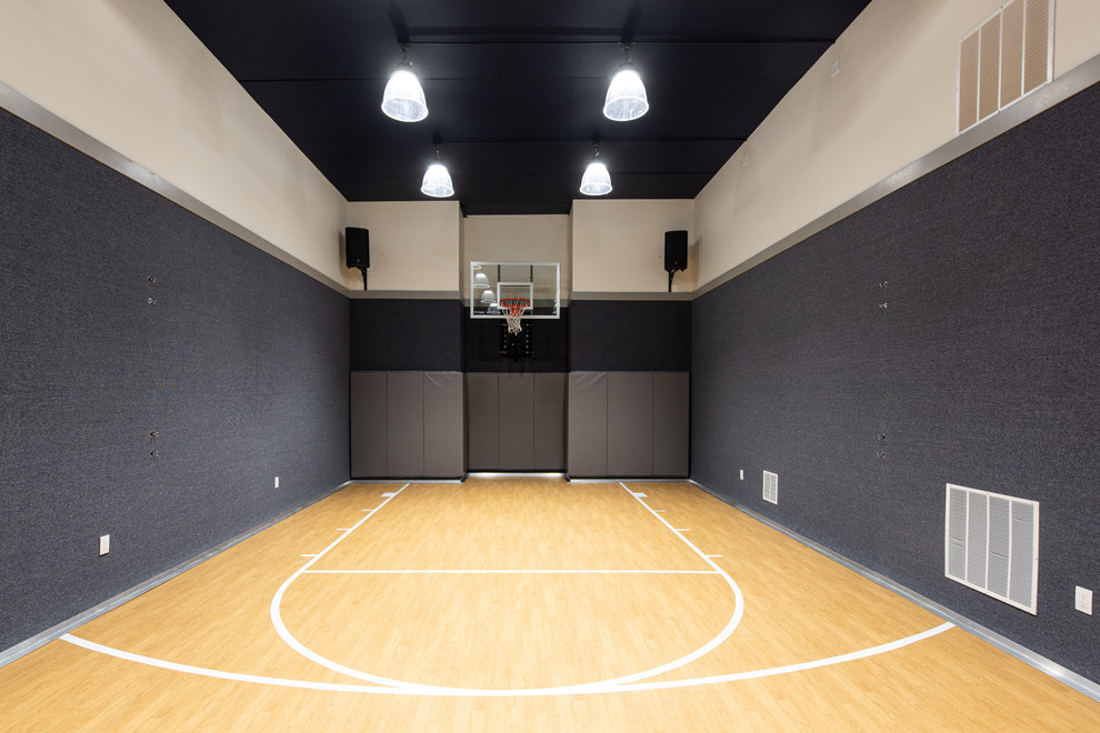 Immagine di un campo sportivo coperto minimal di medie dimensioni con pareti beige, parquet chiaro e pavimento marrone