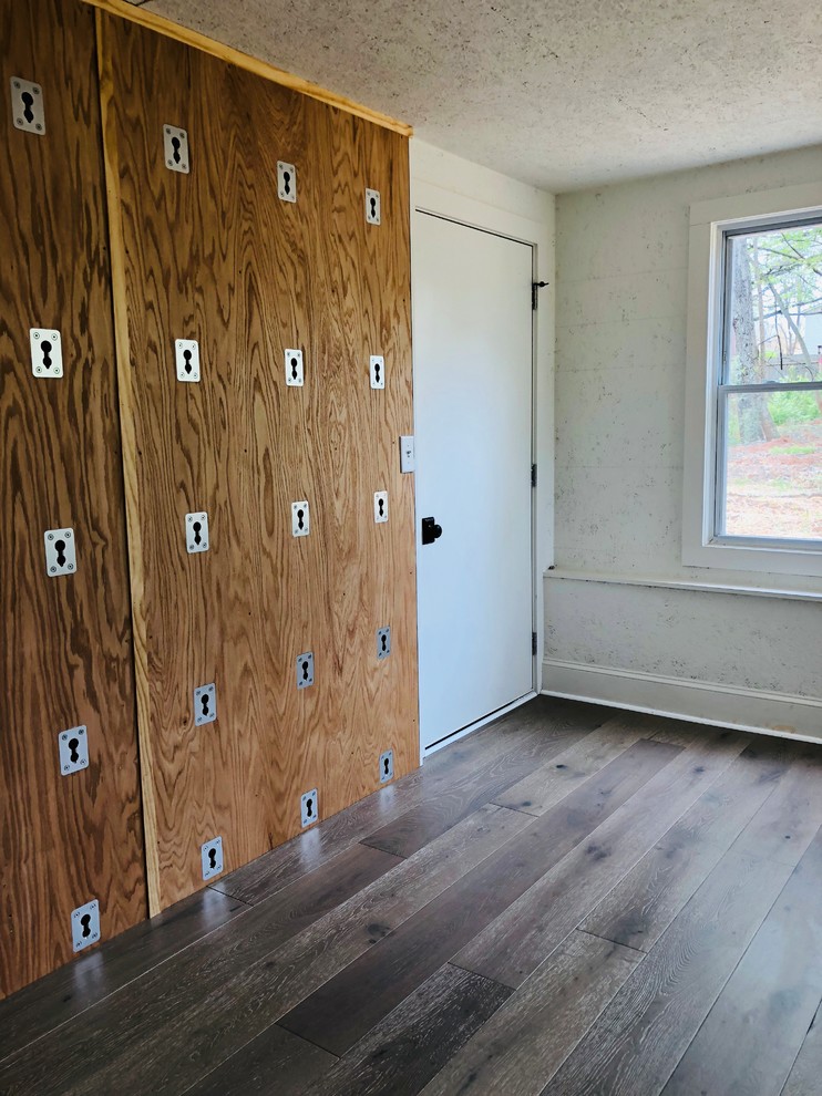 Amerikansk inredning av ett hemmagym med yogastudio, med vita väggar, laminatgolv och brunt golv
