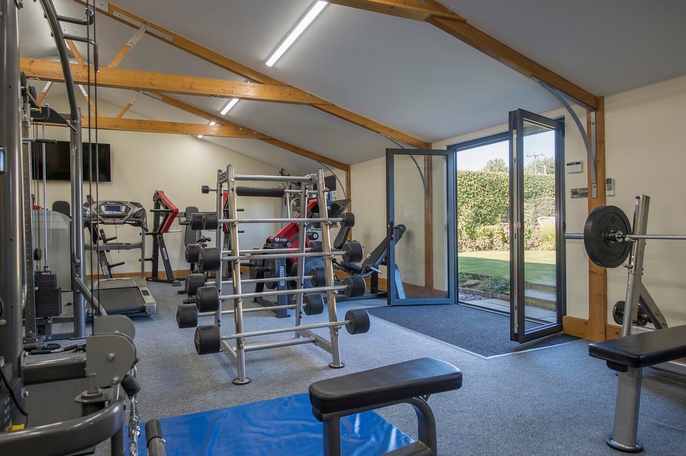 Large farmhouse home weight room in Other with beige walls, carpet and grey floors.