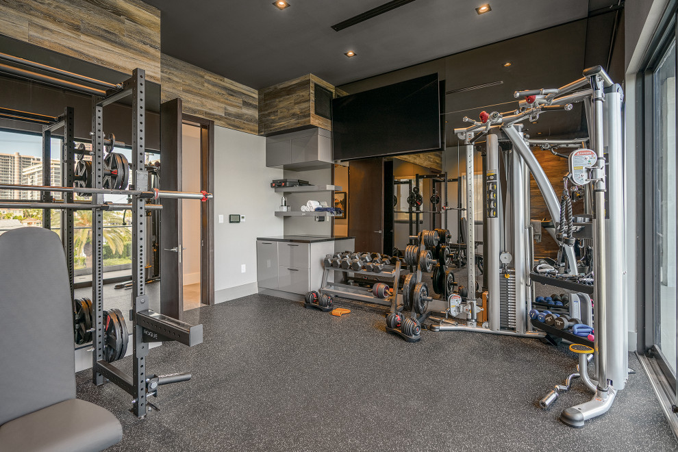Imagen de sala de pesas contemporánea con paredes grises y suelo gris