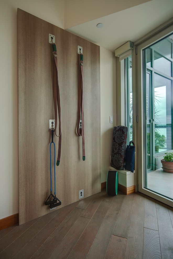 Multifunktionaler Moderner Fitnessraum mit braunem Holzboden in Sonstige