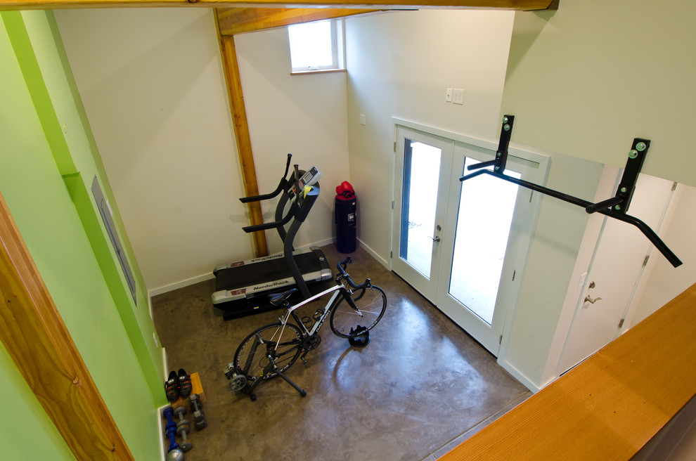 Cette image montre une salle de sport minimaliste multi-usage et de taille moyenne avec un mur vert et sol en béton ciré.