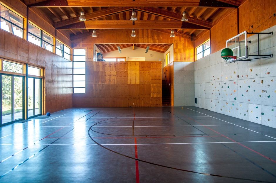На фото: большой спортзал в современном стиле с серыми стенами, коричневым полом и полом из винила