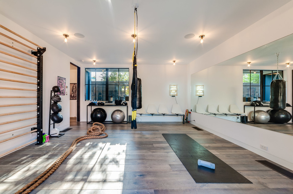 Multifunktionaler, Mittelgroßer Moderner Fitnessraum mit weißer Wandfarbe, grauem Boden und braunem Holzboden in Los Angeles
