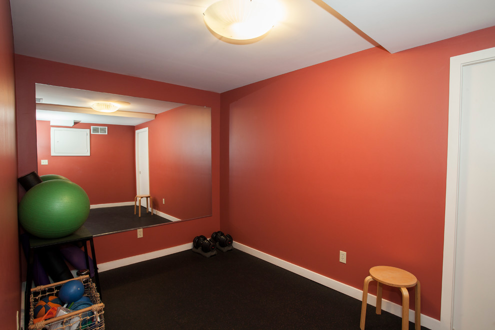Immagine di una sala pesi minimalista di medie dimensioni con pareti arancioni e pavimento in sughero