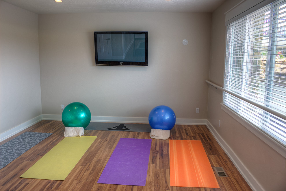 Immagine di uno studio yoga chic di medie dimensioni con pareti beige e pavimento in legno massello medio