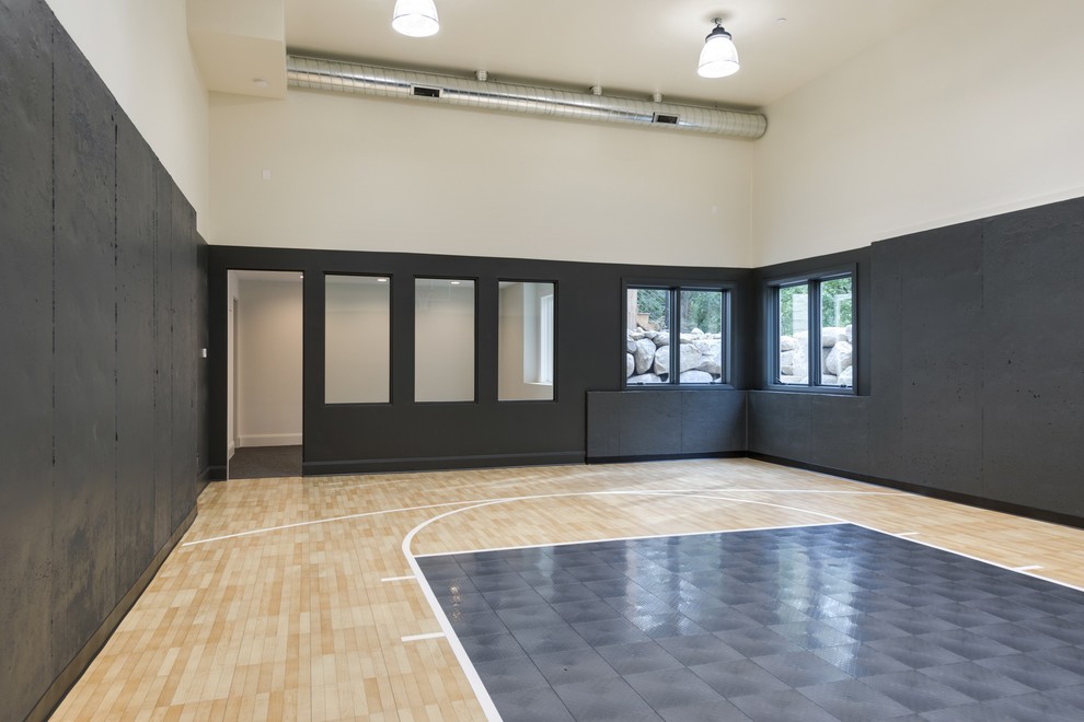 Großer Moderner Fitnessraum mit beigem Boden, Indoor-Sportplatz, schwarzer Wandfarbe und hellem Holzboden in Minneapolis