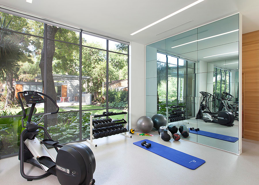 Midcentury multi-use home gym in Austin with white walls.