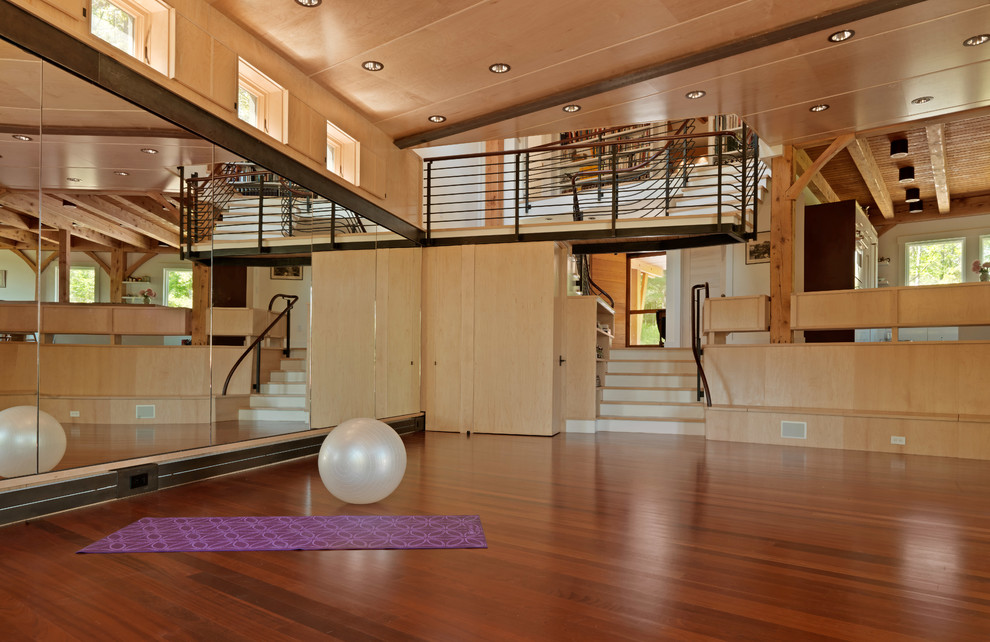 Großer Uriger Yogaraum mit brauner Wandfarbe, dunklem Holzboden und braunem Boden in Burlington
